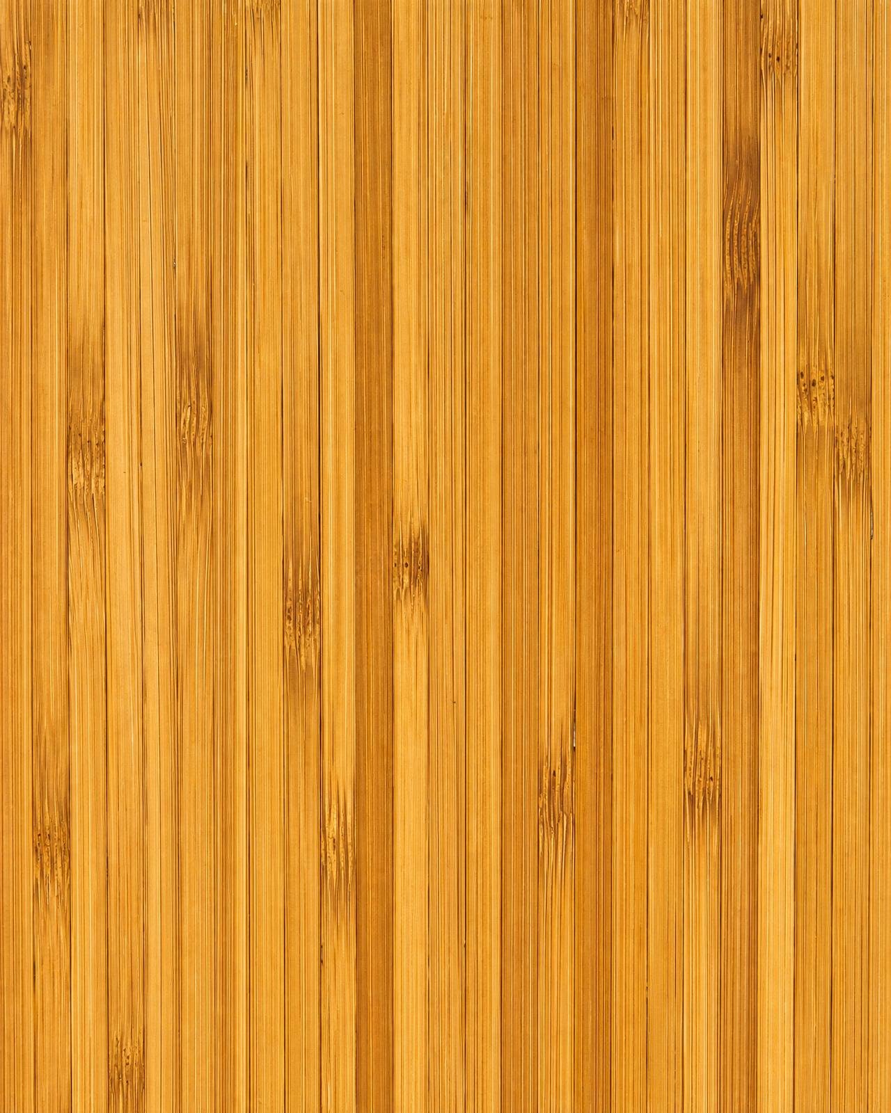 Macro of strand-woven bamboo flooring with linear grain pattern in caramel honey tone