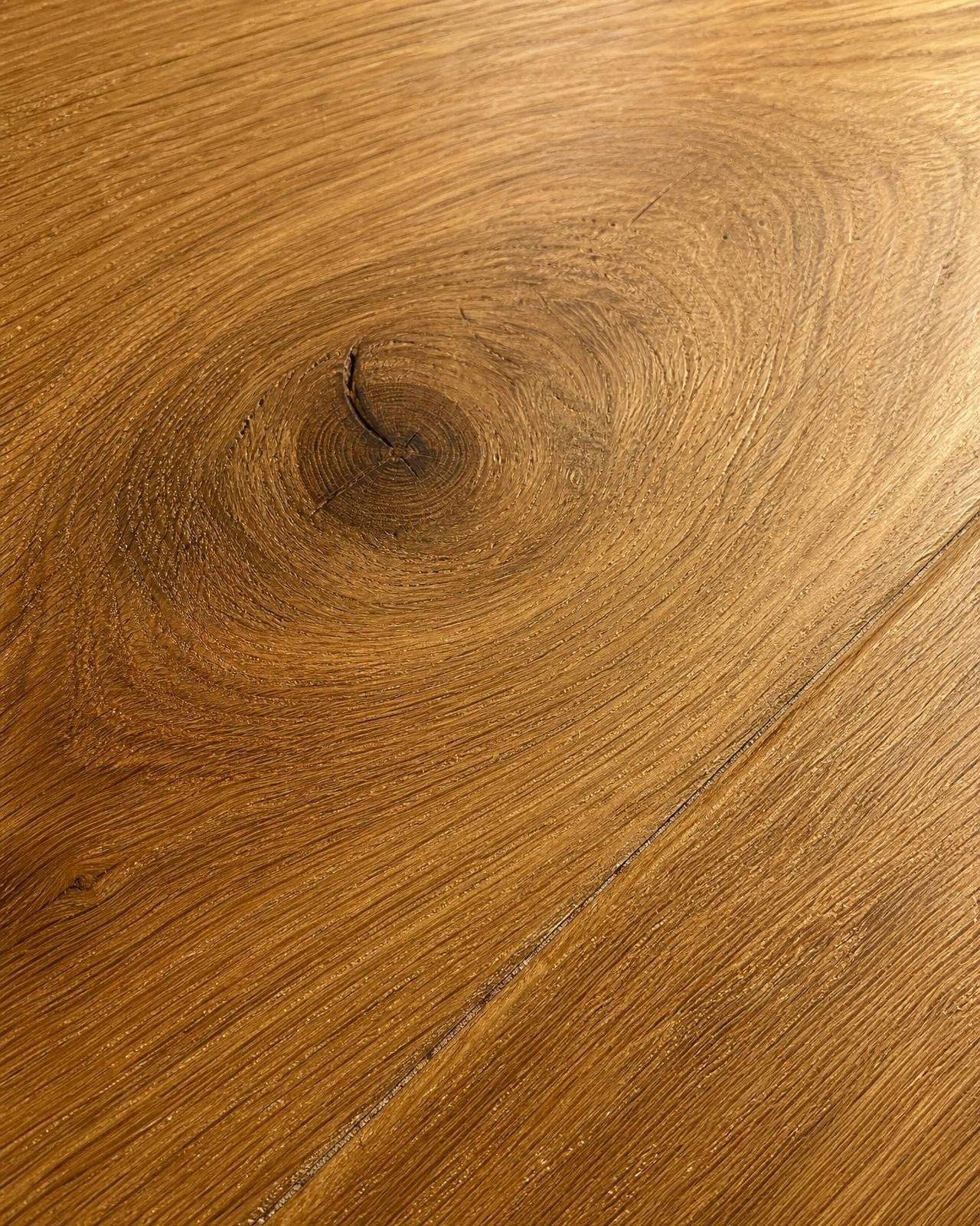 Macro of brushed oil-finished European oak engineered plank with visible grain and knot