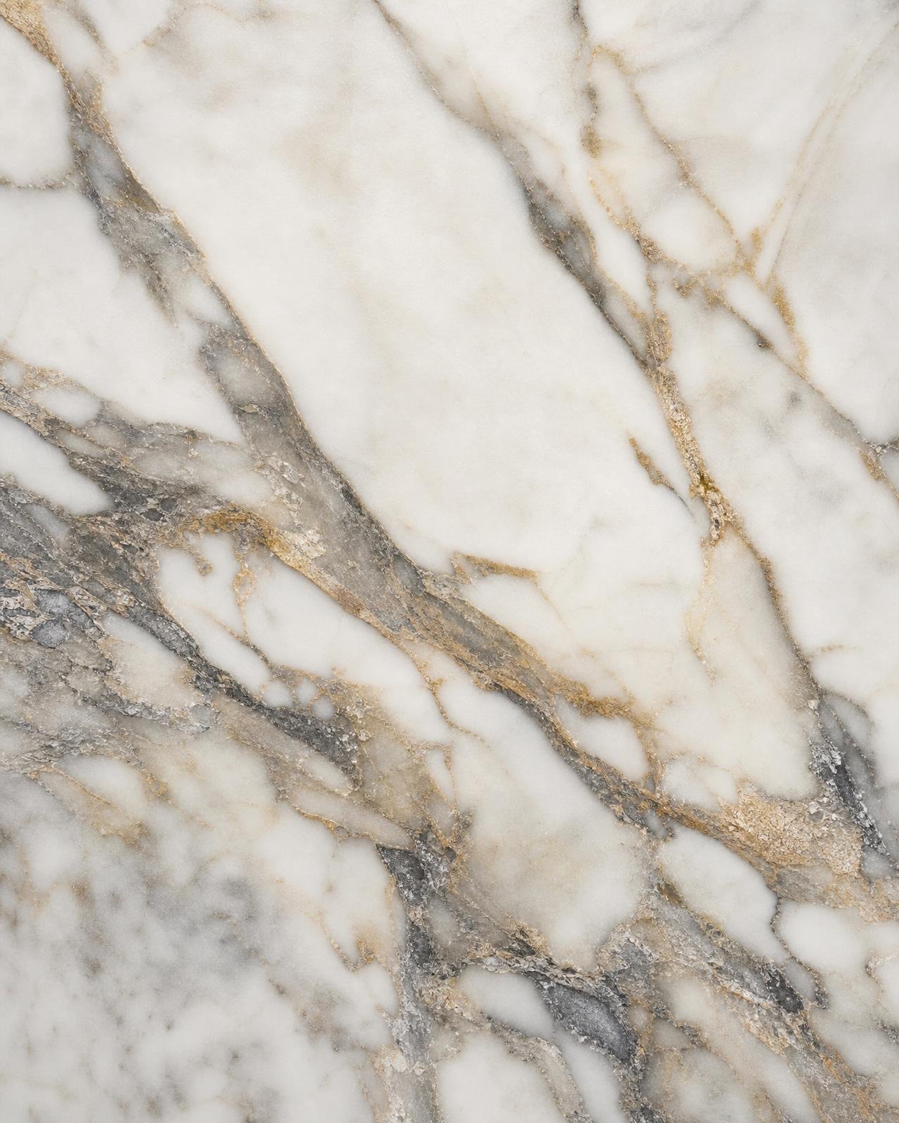 Macro of honed Calacatta marble showing dramatic grey and gold veining