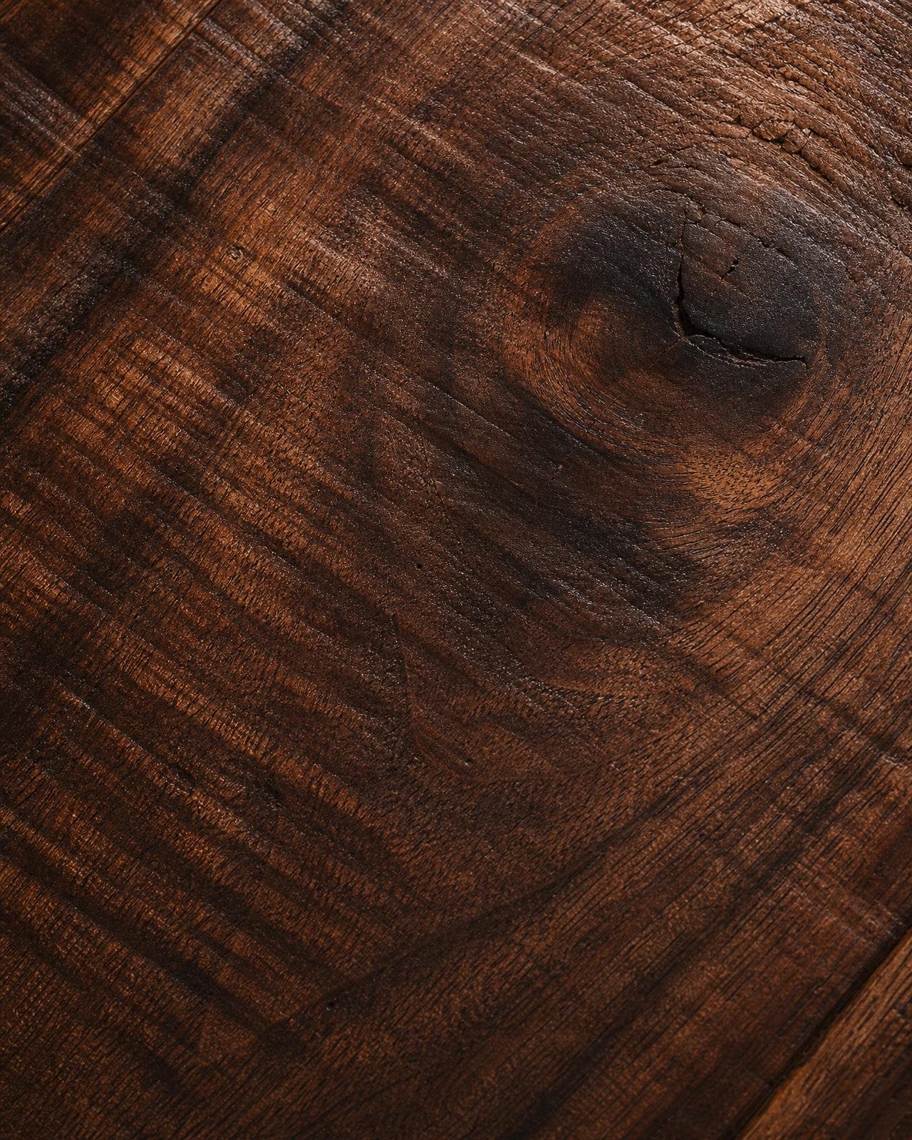 Macro of solid American walnut floor plank with deep grain and hand-finished surface