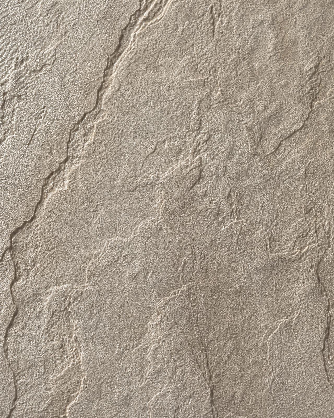 Macro of embossed stone-effect commercial vinyl wallpaper with subtle veining