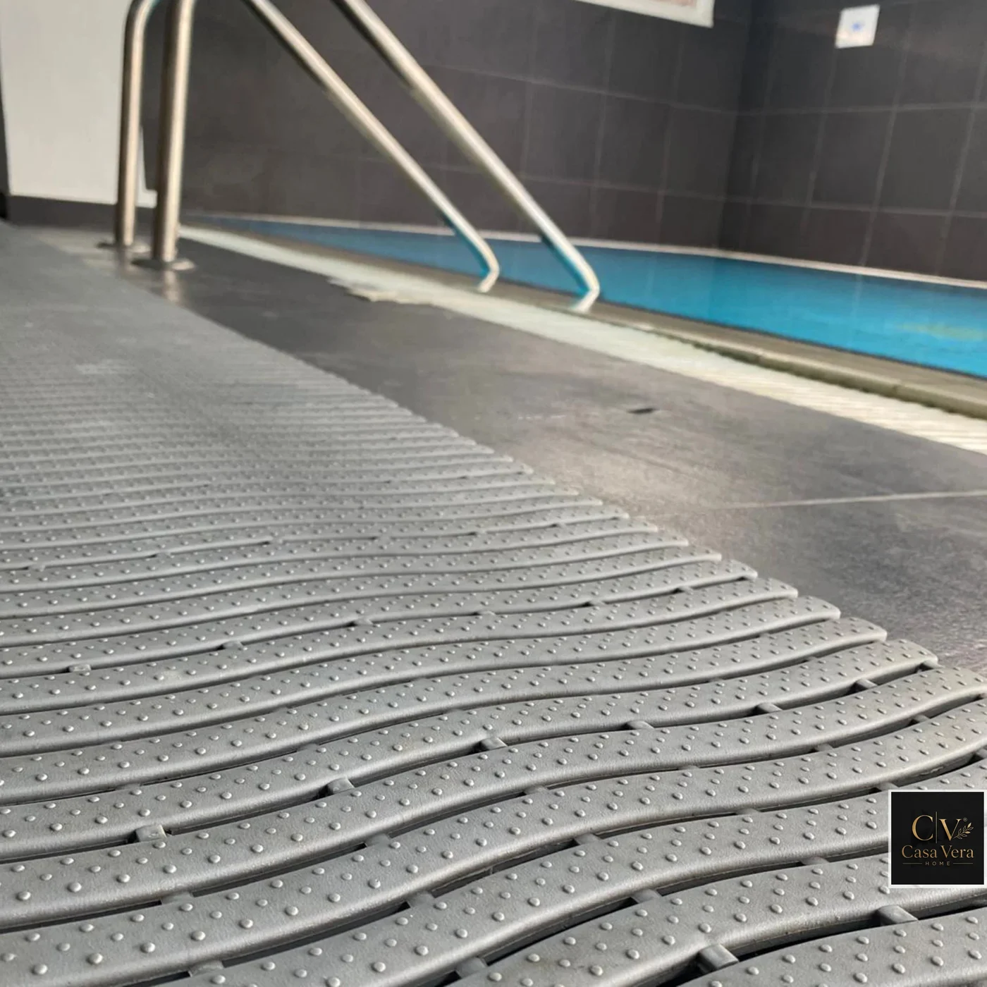 Grey CV-Wave drainage matting laid along a tiled indoor pool surround