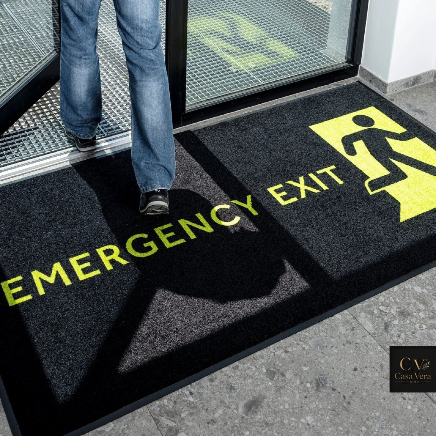Black high-visibility mat printed with a yellow emergency exit message and pictogram