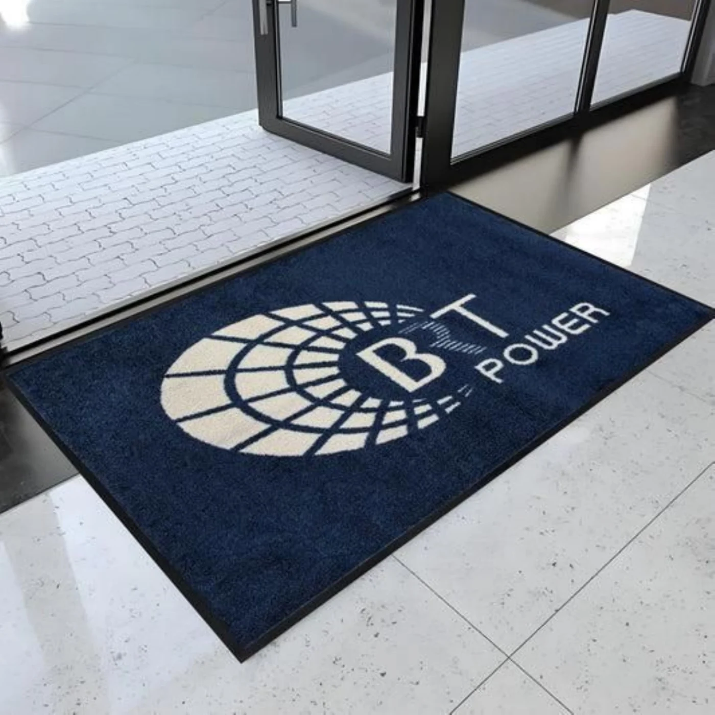 Navy Jet Print logo mat with a white emblem photographed on a polished commercial floor